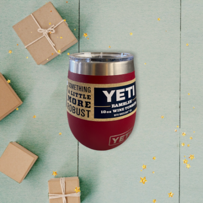 A maroon Yeti brand wine tumbler on a Christmas background.